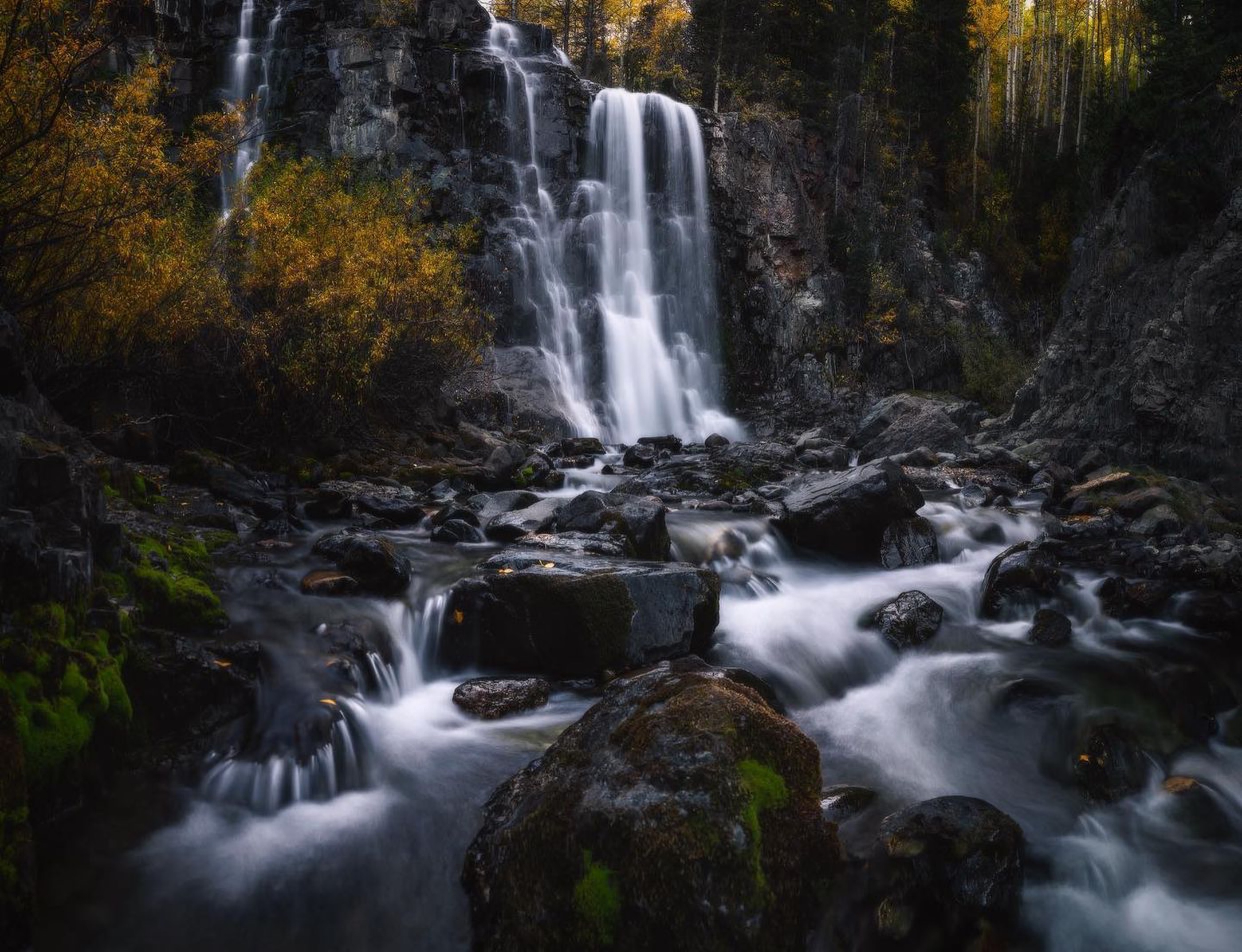 Long exposure of a Colorado waterfall surrounded by autumn foliage