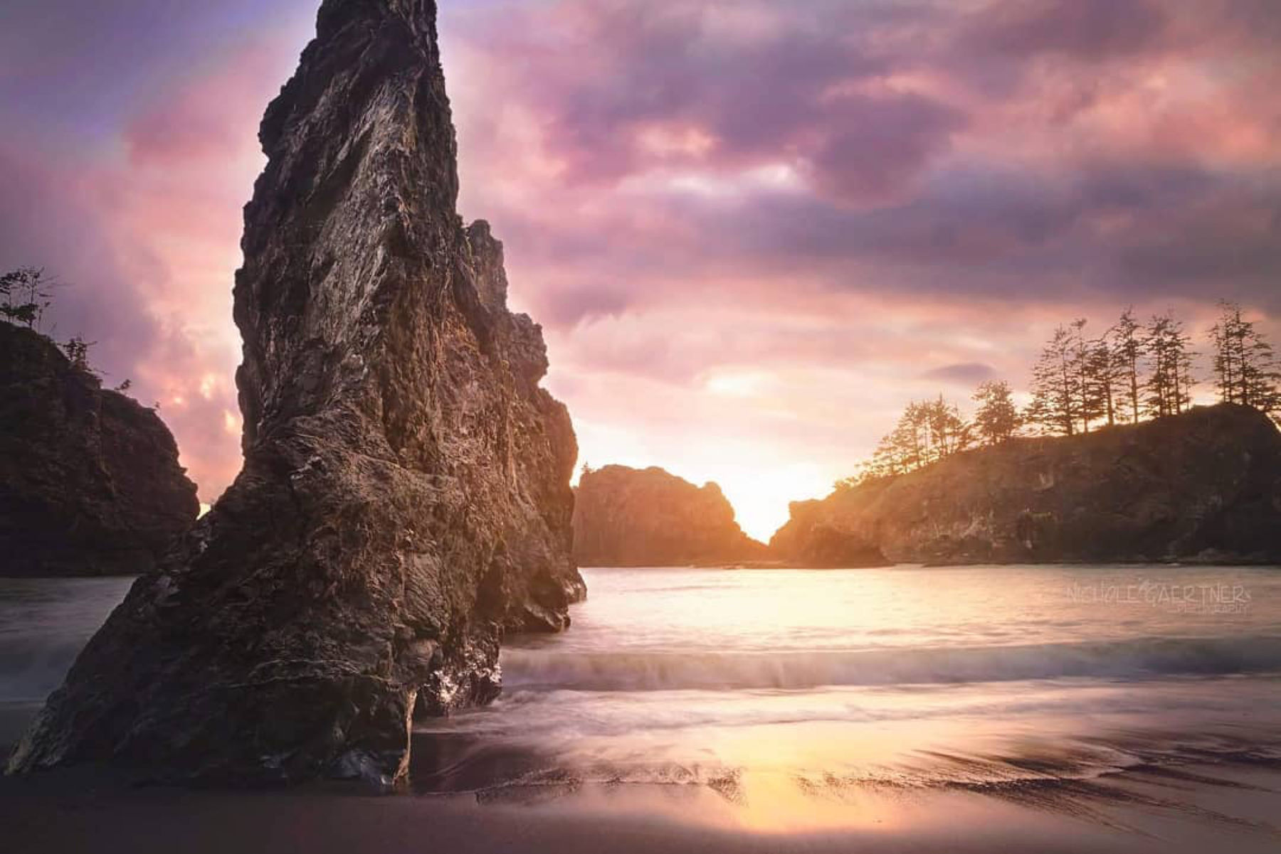 Fiery sunset behind Secret Beach sea stacks photographed by student Nichole G.