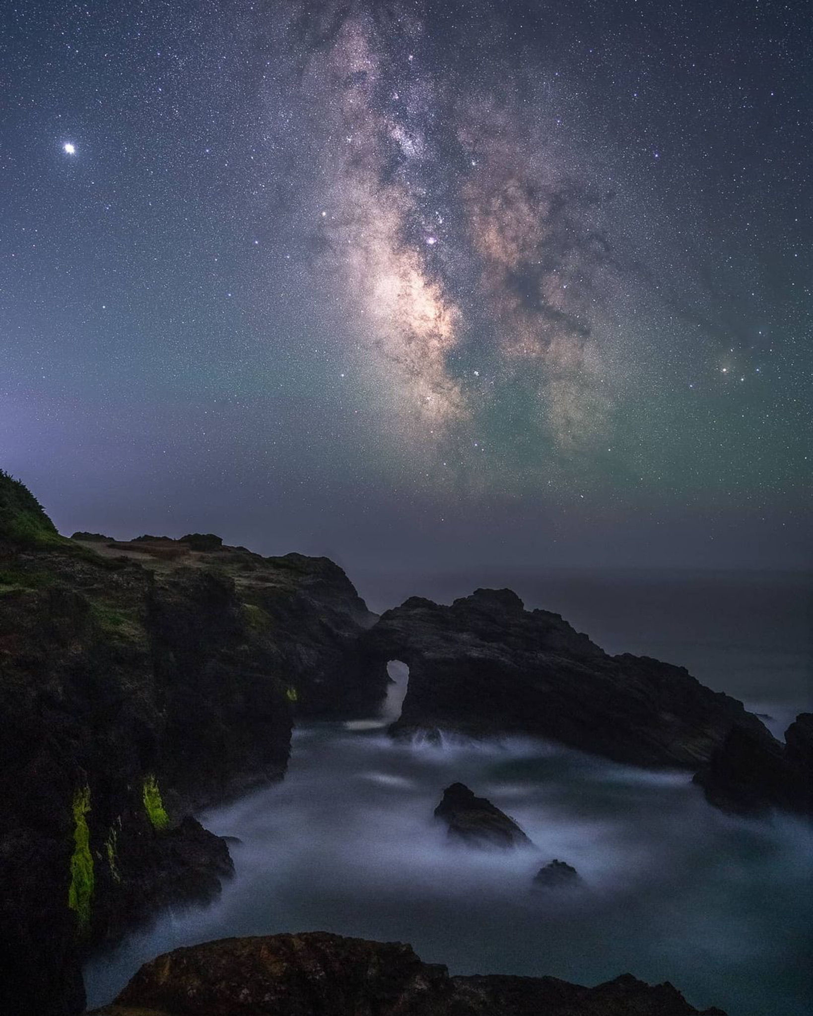 Milky Way above a rocky Oregon coastline photographed by student Jen P.