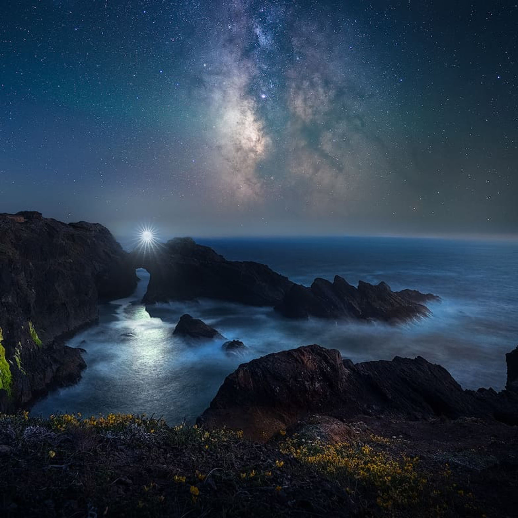 Instructor headlamp beneath the Milky Way at a coastal rock arch photographed by student Jen P.