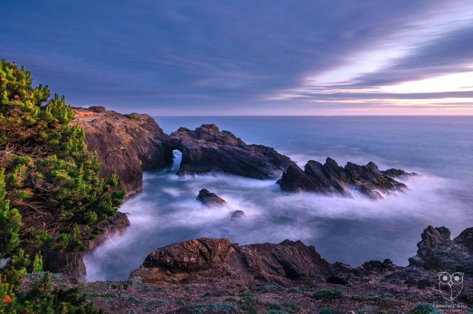 Natural coastal rock arch during sunset photographed by student Andrea W.
