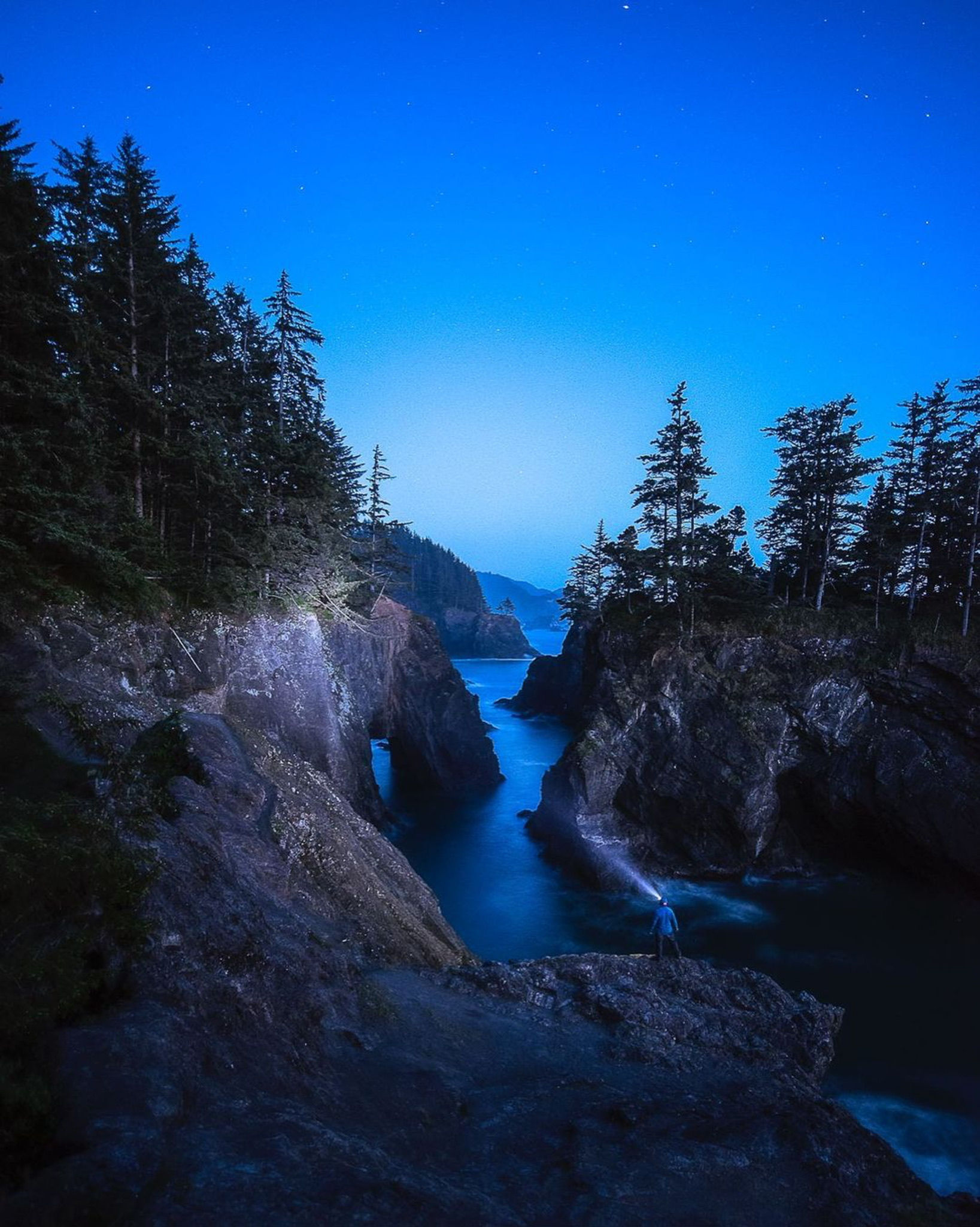 Natural bridge and an instructor headlamp at blue hour photographed by student Setul P.
