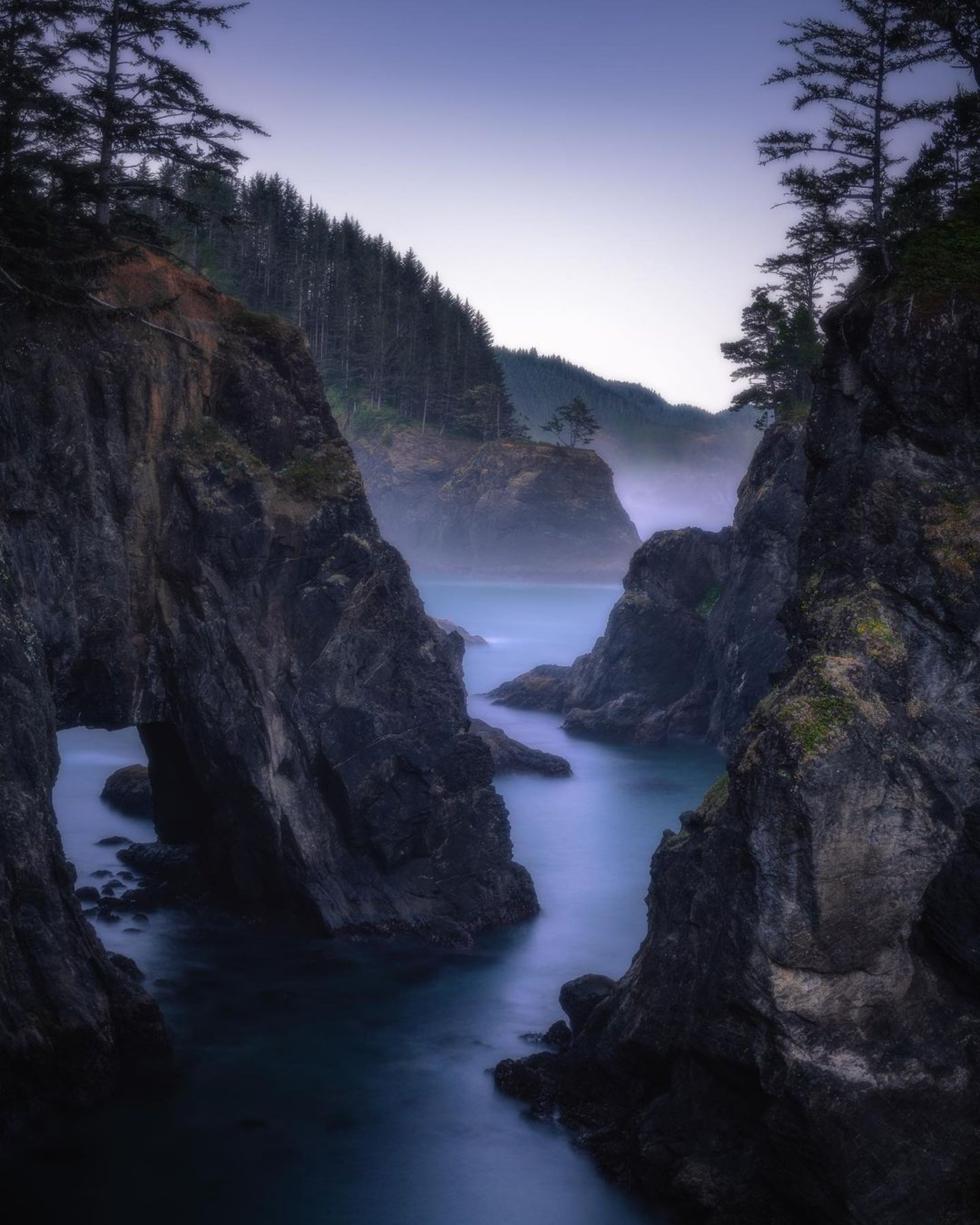 Blue-hour view through rugged Oregon Coast sea stacks