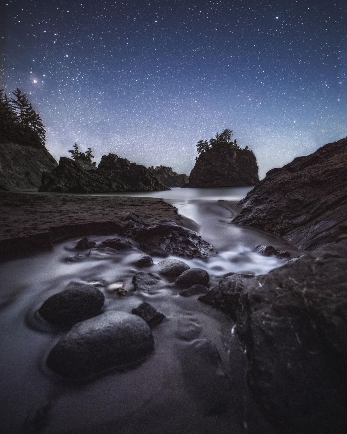 Milky Way above rocks and a creek on the Oregon Coast at night