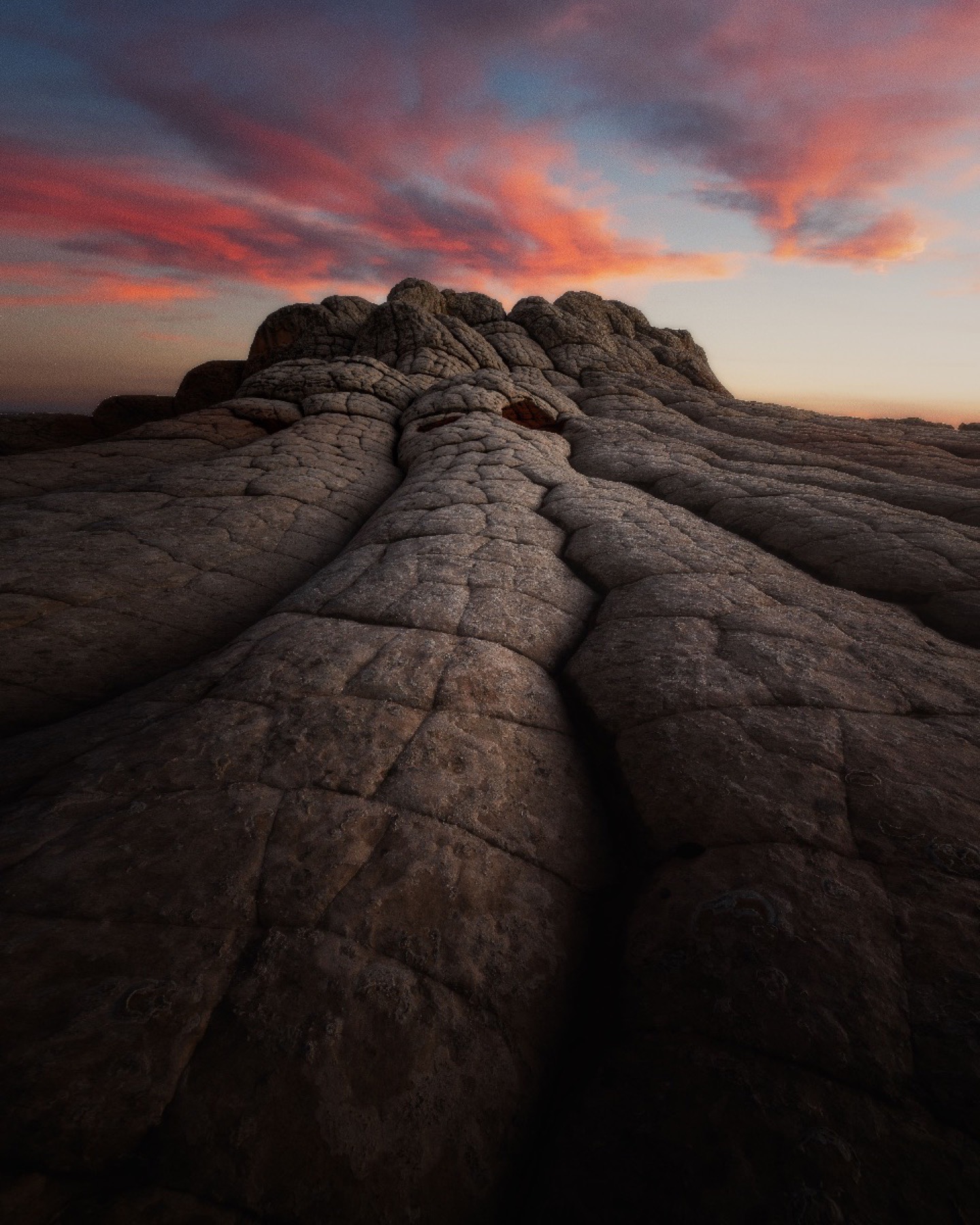Rounded White Pocket sandstone rising beneath pink sunset clouds