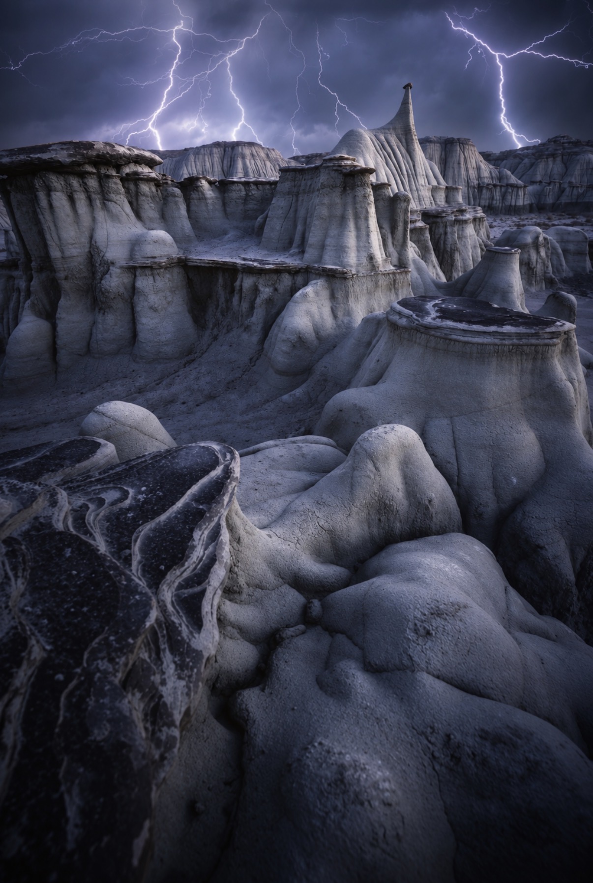 Lightning over the Bisti Badlands beneath a storm-filled sky