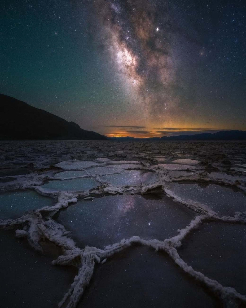 Repeating salt polygons in Death Valley lead toward a bright interruption beneath the Milky Way.